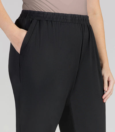 Close-up, bottom half of plus sized woman, wearing JunoActives SoftWik Relaxed Fit Long Capris with Pockets in black. Hemline ends at mid-calf of model.