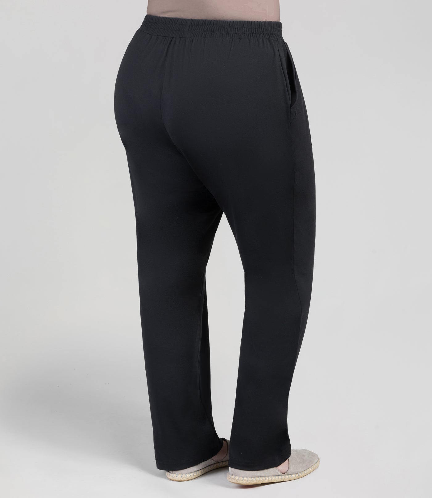 Back view, bottom half of plus sized woman, wearing JunoActives Softwik Relaxed fit pocketed pant and is full length. Color is black.