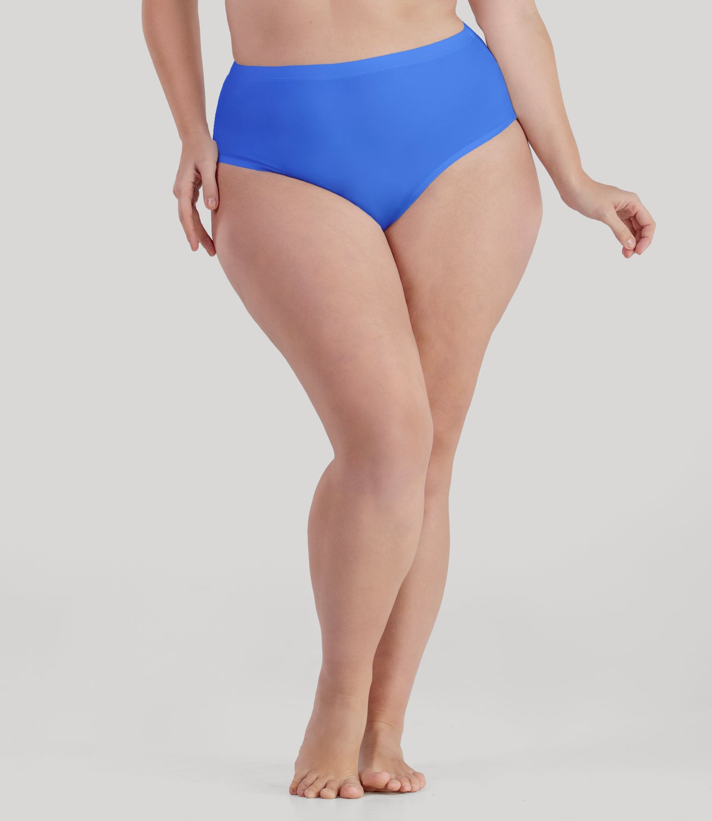 Bottom half of plus sized woman, facing front, wearing JunoActive QuikWik Comfort Briefs in true blue. This brief fits just below the belly button with conservative leg opening.