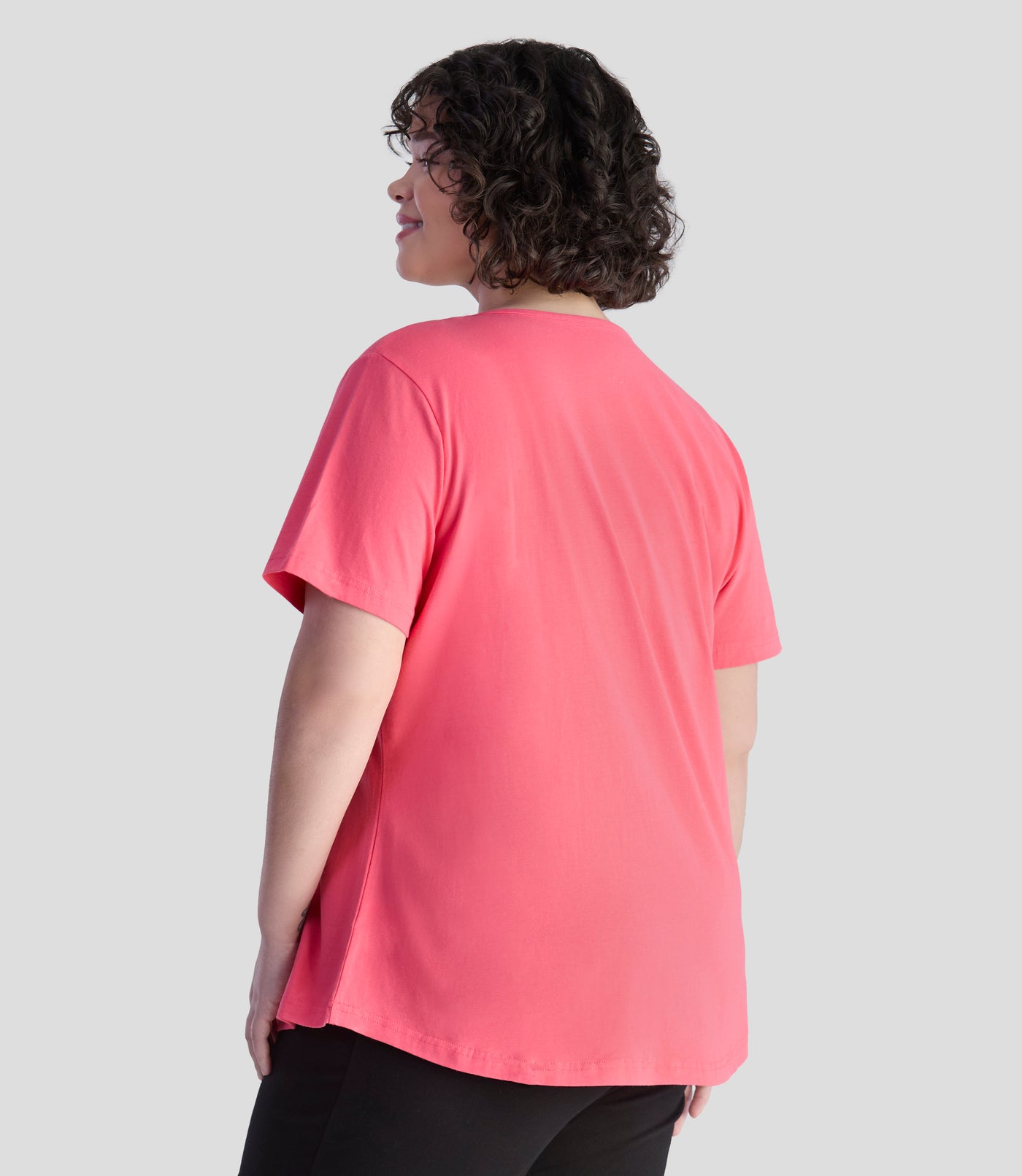 Model is back forward with her arms by her side. She is wearing JunoActive's Designer Graphic scoop neck in color carnation pink.