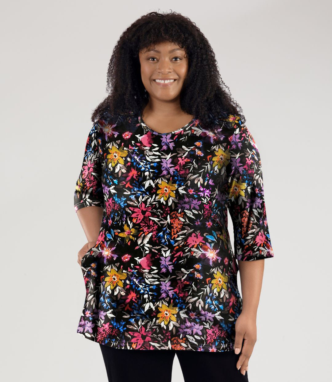 Model, facing front, wearing JunoActive's Junonia Lifestyle Printed three quarter sleeve pocketed top in floral forest print.