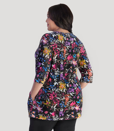Model, facing back, wearing JunoActive's Junonia Lifestyle Printed three quarter sleeve pocketed top in floral forest print.