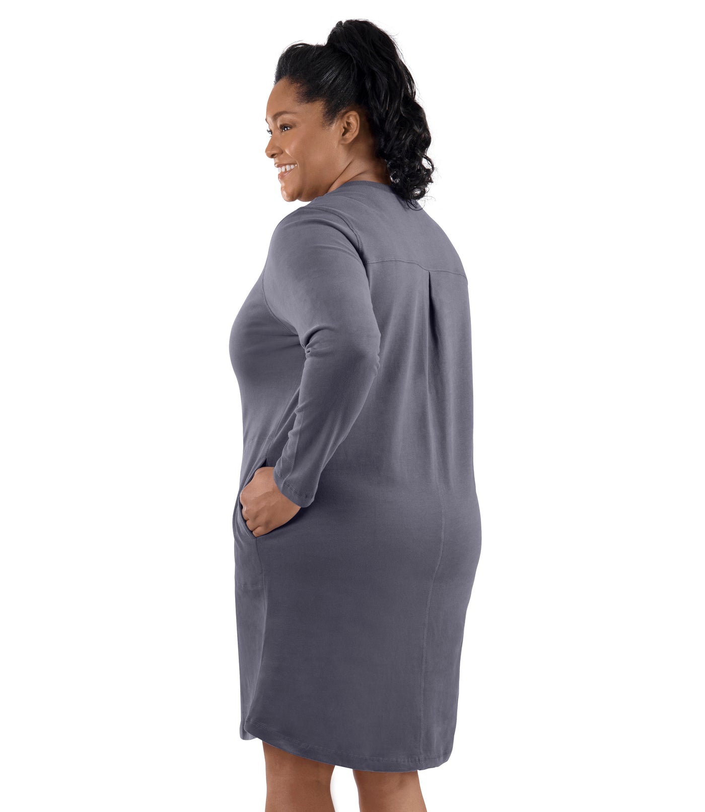 Plus-size model, facing back, left hand in dress pocket. Wearing JunoActive's Legacy Cotton Casual Pocketed Long Sleeve Dress in Misty Grey.