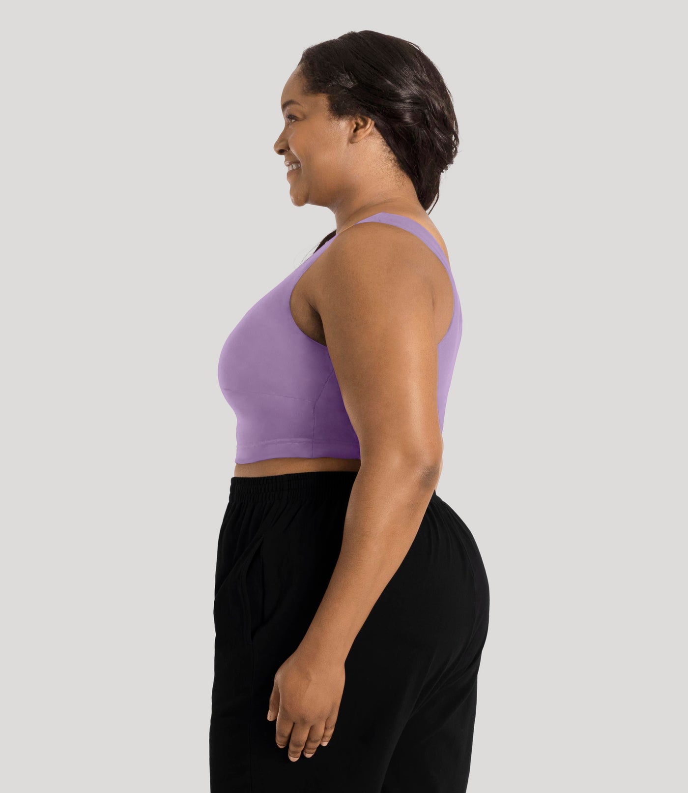 Plus size model, facing side, wearing stretch naturals full fit scoop neck bra in color lavender.