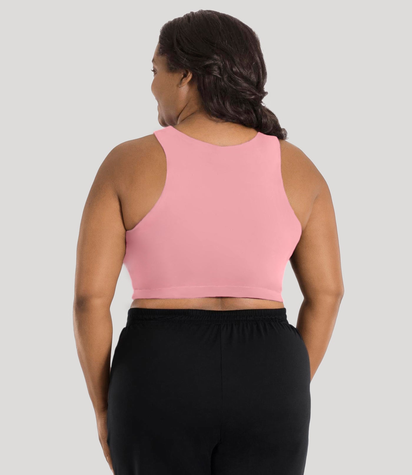 Plus size model, facing back, wearing stretch naturals full fit V-neck plus size bra in color peach fizz.