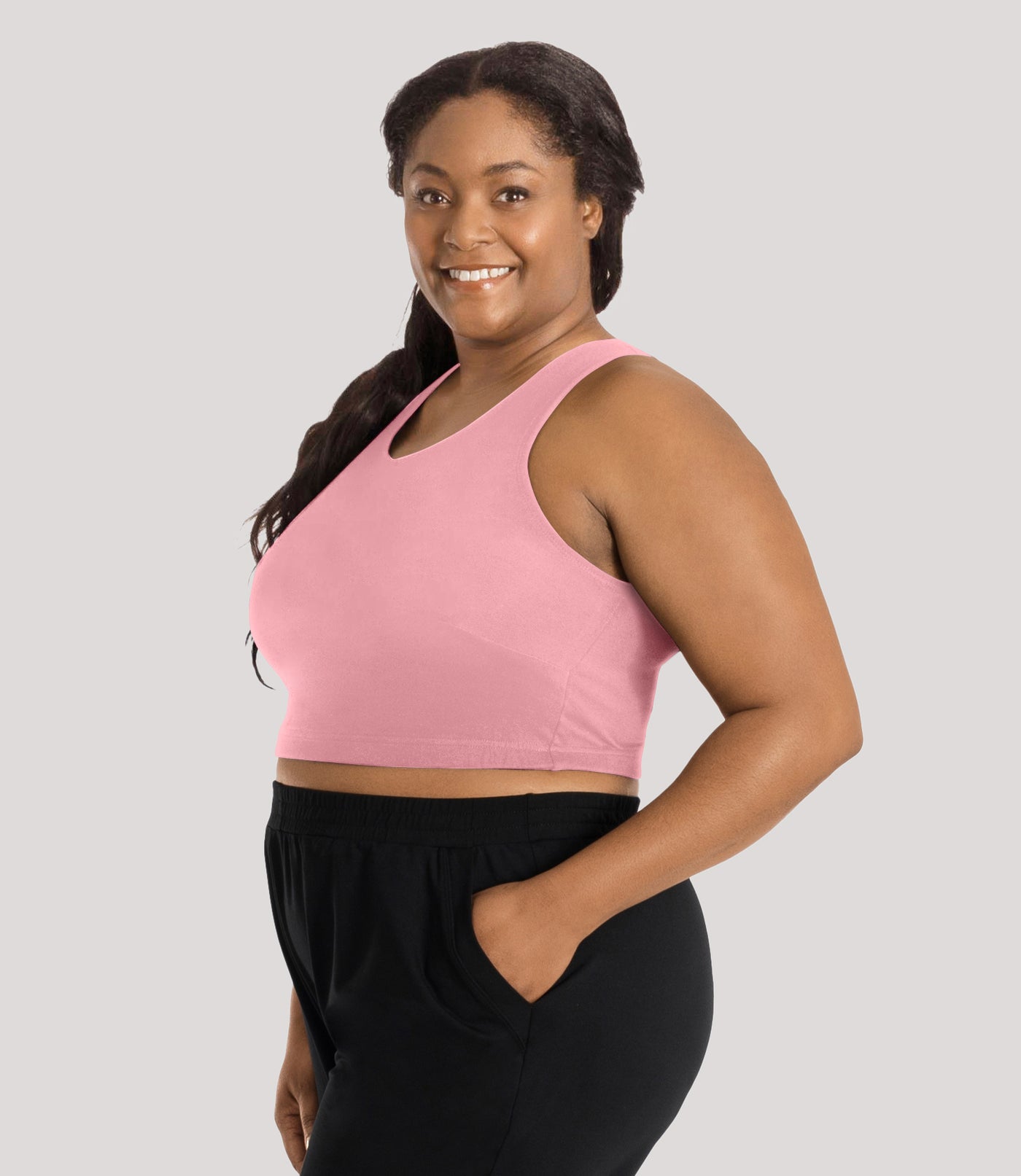 Plus size model, facing side, wearing stretch naturals full fit V-neck plus size bra in color peach fizz.