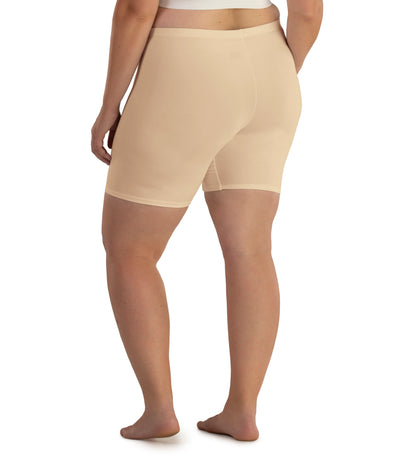 Bottom half of plus sized woman, facing back, wearing JunoActive Junowear Hush Boxer Brief in color ecru. This fitted boxer fits to the waistline and leg opening is a few inches above the knee.