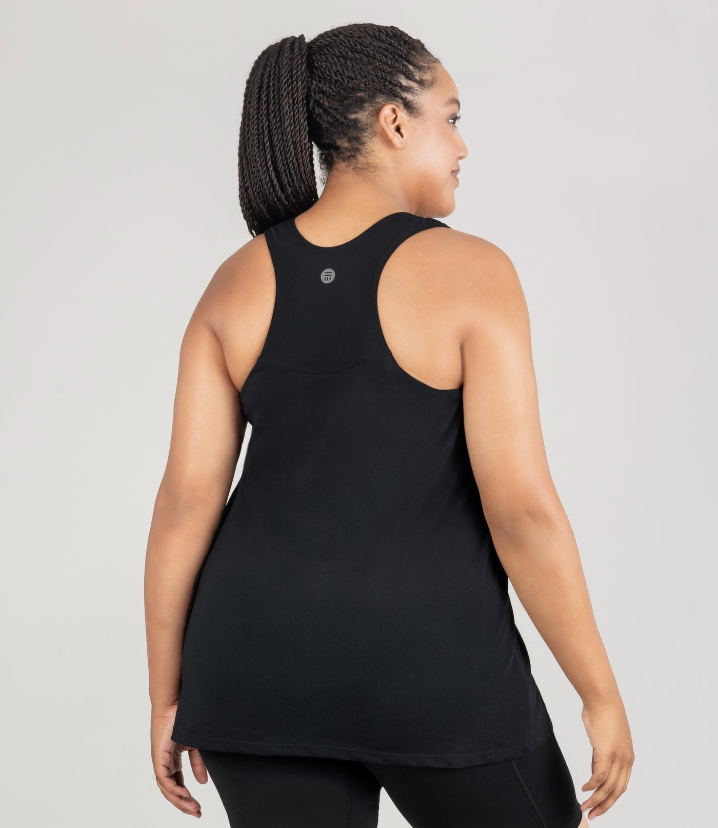 JunoActive model, facing back, is wearing an Aquasport Hanalei Tankin top in color black. Her arms are by her side.