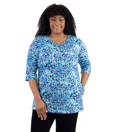 JunoActive Lifestyle Cotton three quarter sleeve pocketed tunic in print Monet. Model facing front with one hand in shirt.
