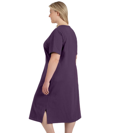 Plus size woman, facing to back left, wearing JunoActive plus size Stretch Naturals Short Sleeve Dress in the color Blackberry. 