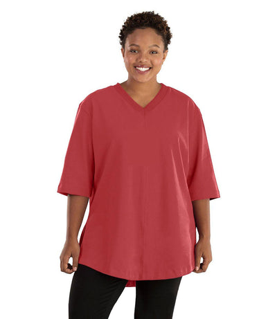 Plus size woman, facing front, wearing JunoActive plus size Legacy Cotton Casual Tunic in the color Sedona Red. She is wearing JunoActive Plus Size Leggings in the color black.