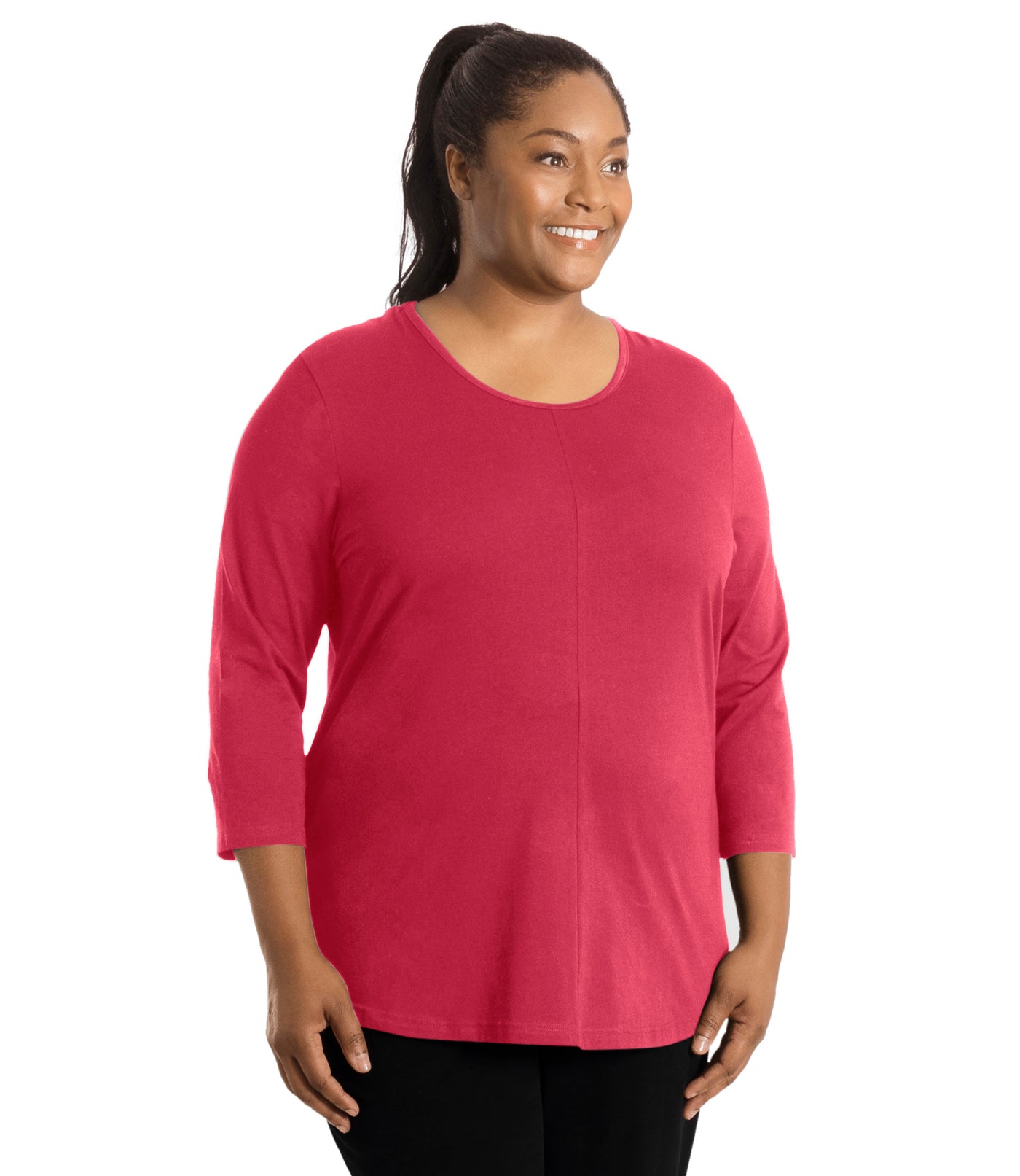 Plus size woman, facing front, wearing JunoActive’s Stretch Naturals Center Seam Scoop Neck 3/4 sleeve top in color Coraline. Hands are by side. Pants are in color black. 