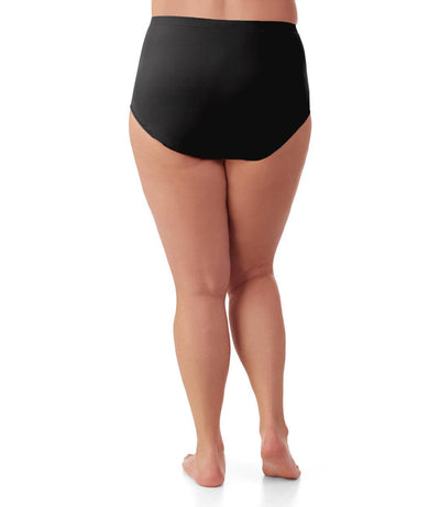 Bottom half of plus sized woman, back view, wearing JunoActive Junowear Hush Briefs in black. This brief fits to the waistline with conservative leg opening.