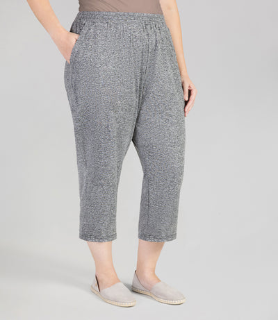 Front view, bottom half of plus sized woman, wearing JunoActives SoftWik Relaxed Fit Long Capris with Pockets in heather grey. Hemline ends at mid-calf of model.