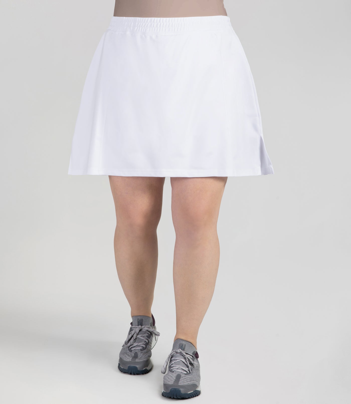Bottom half of plus sized woman, front view, wearing JunoActives Quikwik lite skirted short in color white. Skirt hem is a few inches above knee.