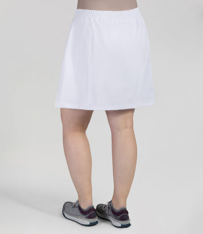 Bottom half of plus sized woman, back view, wearing JunoActives Quikwik lite skirted short in color white. Skirt hem is a few inches above knee.