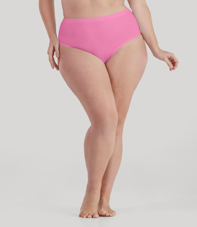 Bottom half of plus sized woman, facing front, wearing JunoActive QuikWik Comfort Briefs in power pink . This brief fits just below the belly button with conservative leg opening.