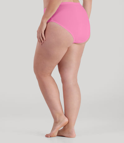 Bottom half of plus sized woman, facing back, wearing JunoActive QuikWik Comfort Briefs in power pink . This brief fits just below the belly button with conservative leg opening.