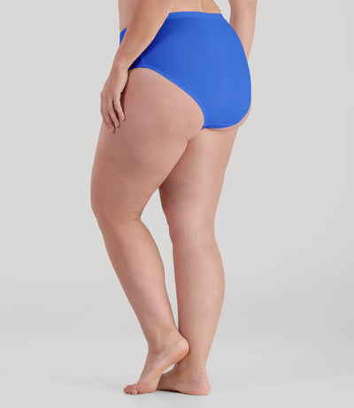 Bottom half of plus sized woman, facing back, wearing JunoActive QuikWik Comfort Briefs in true blue. This brief fits just below the belly button with conservative leg opening.