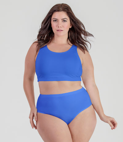 Plus size woman, facing front, wearing JunoActive plus size QuikWik Soft Control Bra Top in True Blue.