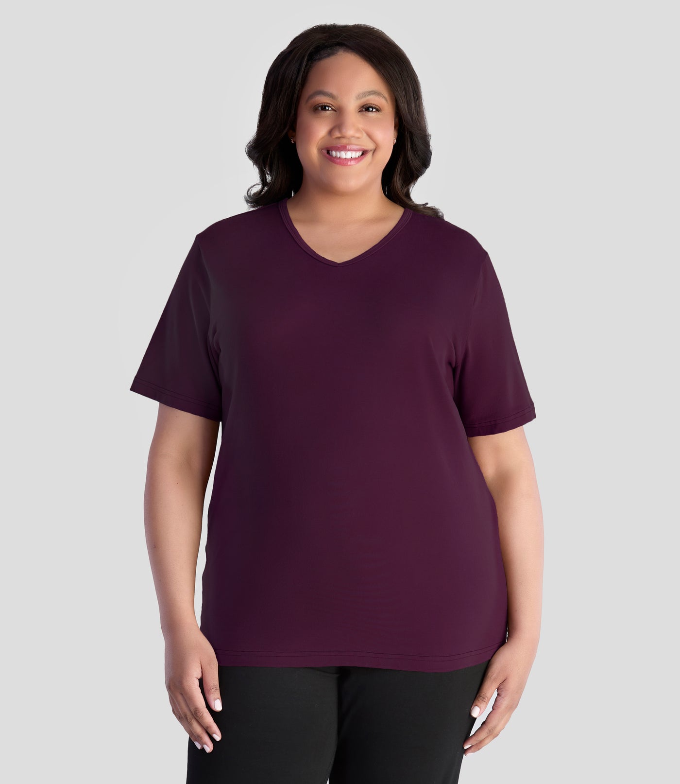 JunoActive model wearing EasyLuxe Classics V-Neck Top  in color wine. Model is facing forward with her arms by her side.