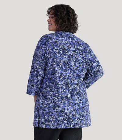 Plus size model, facing back, wearing EZ Style Cotton plus size 3/4 Sleeve Split Neck Tunic with Pockets in blue meadow print.