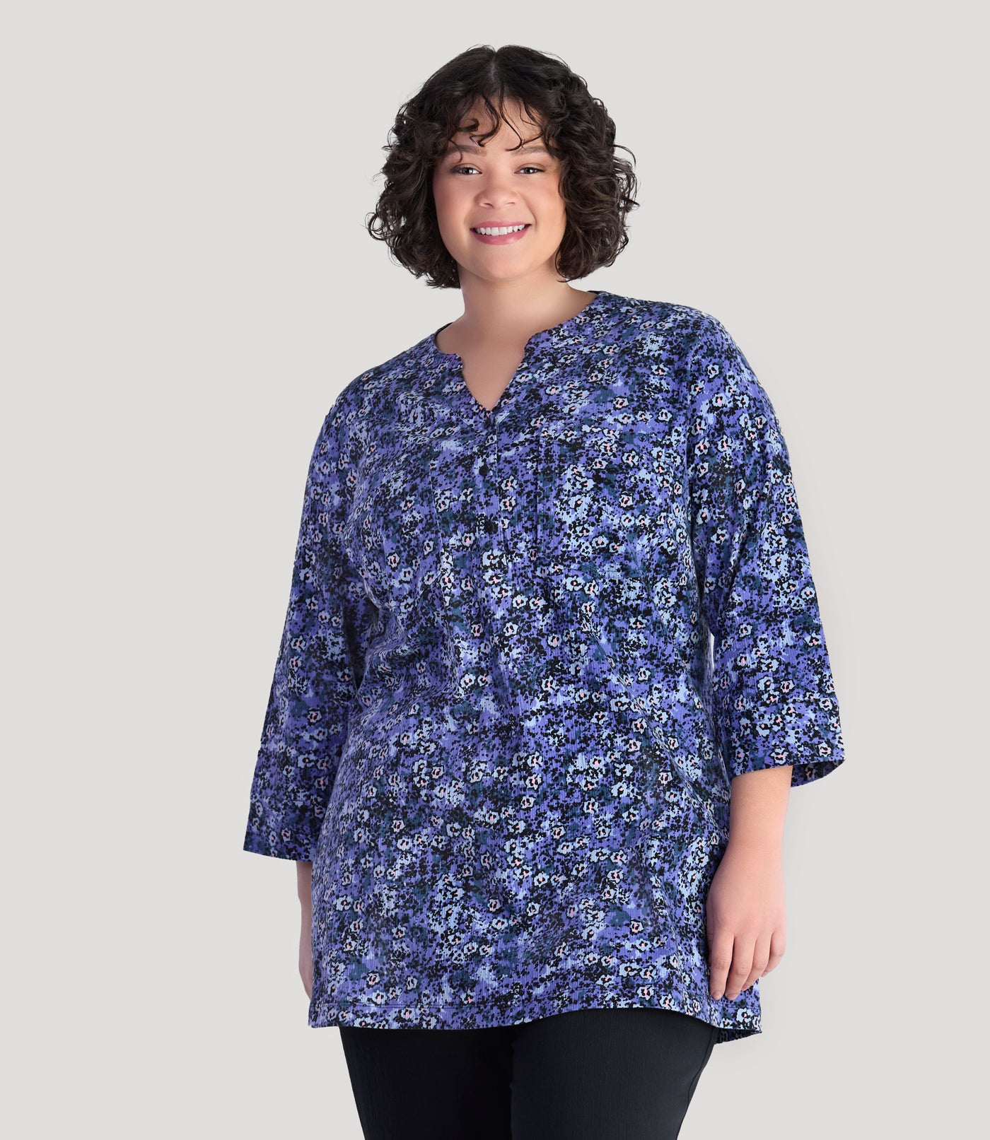 Plus size model, facing front, wearing EZ Style Cotton plus size 3/4 Sleeve Split Neck Tunic with Pockets in blue meadow print.