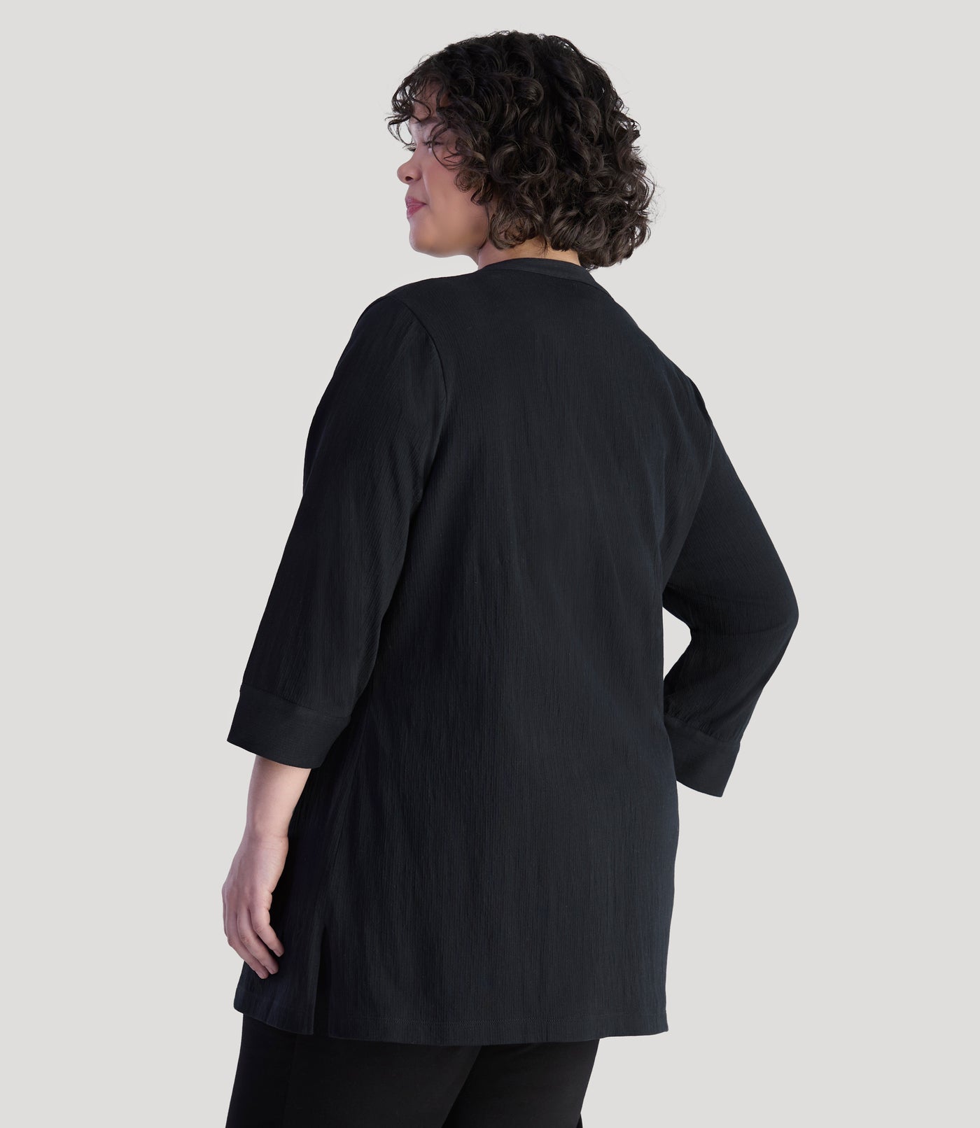 Plus size model, facing back, wearing EZ Style Cotton plus size 3/4 Sleeve Split Neck Tunic with Pockets in color black.