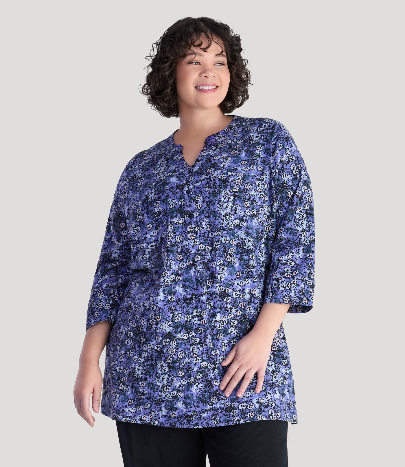 Plus size model, facing front, wearing EZ Style Cotton plus size 3/4 Sleeve Split Neck Tunic with Pockets in blue meadow print.
