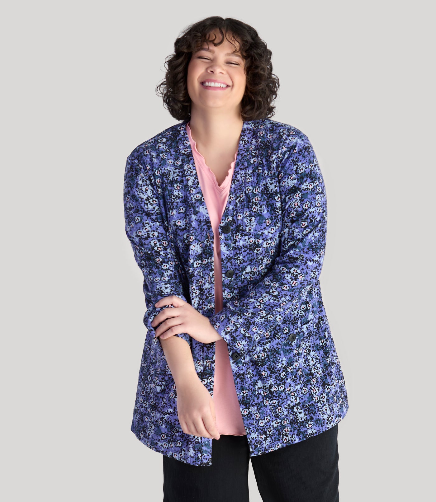 Model, facing front, wearing JunoActive's plus size EZ Style Cotton Long Sleeve Pocket plus size Jacket in color blue meadow print. Model is pushing sleeves up to elbows.