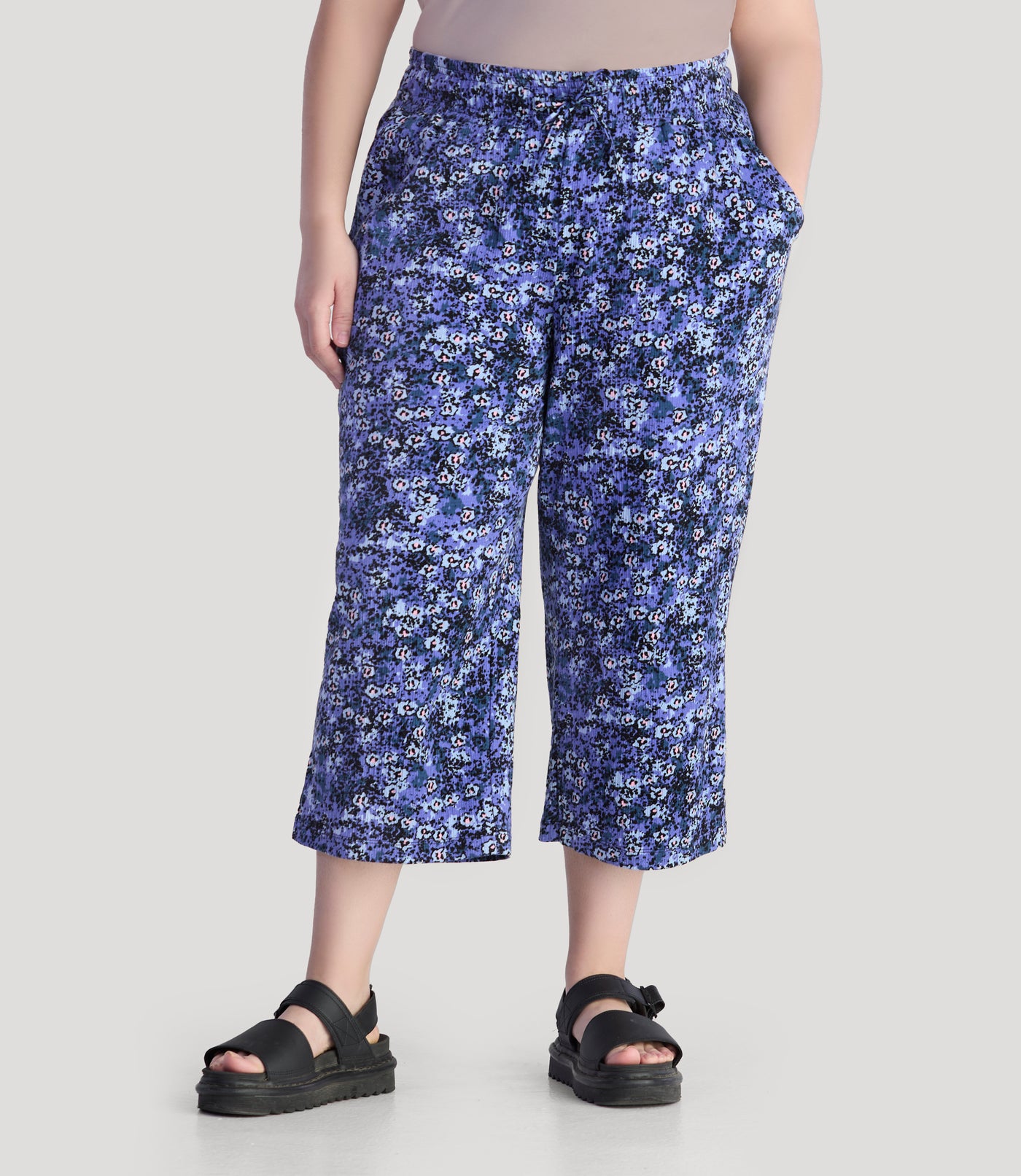 Plus size model, facing front, wearing JunoActive's EZ style cotton pocketed plus size capris in blue meadow print. 