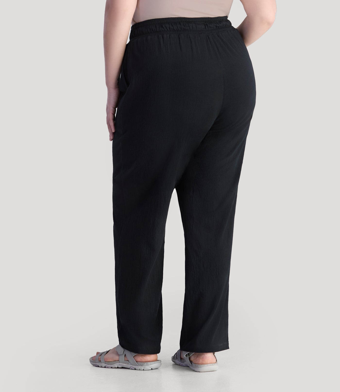 Plus size model, facing back wearing JunoActive's EZ Style Cotton Pocketed plus size Pant in color black.