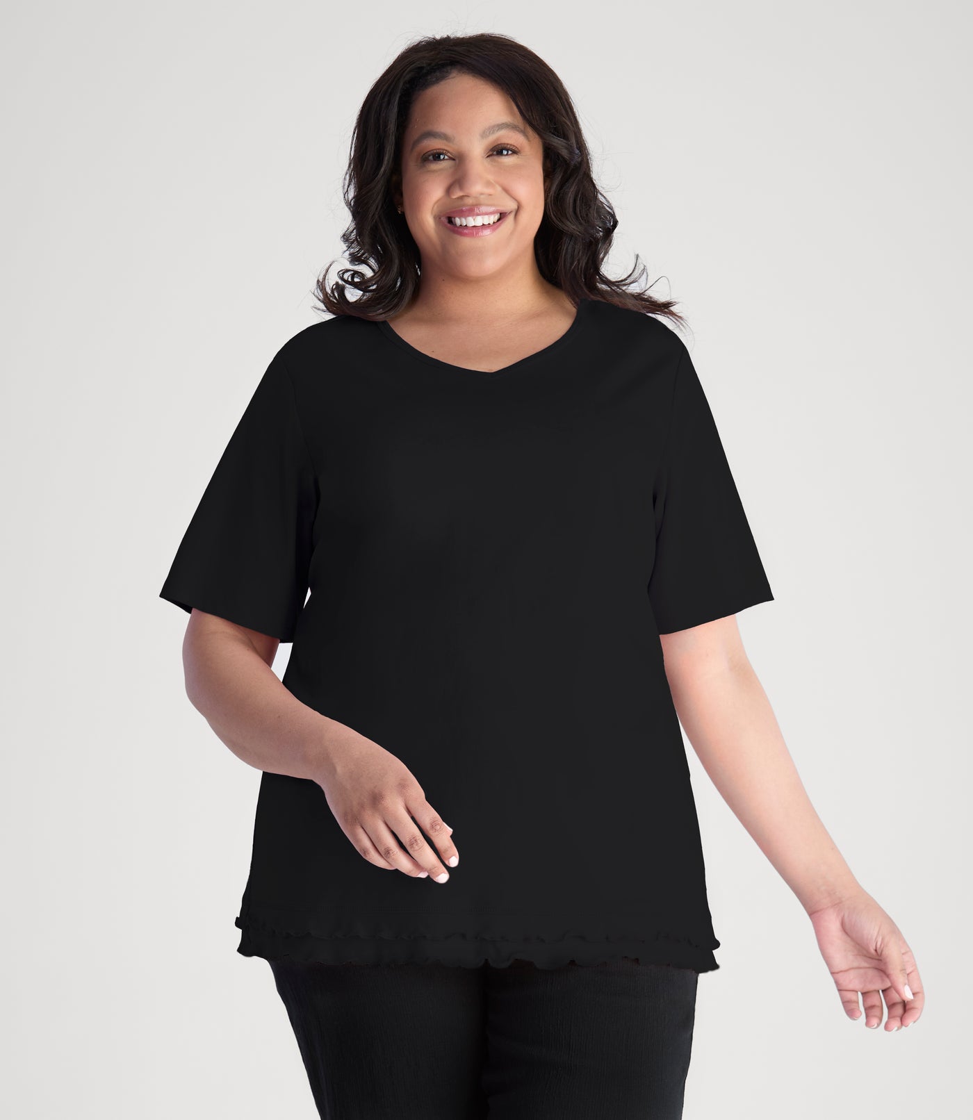 Model, wearing Cotton Chic Lettuce Trim Short Sleeve plus size Top in color black.