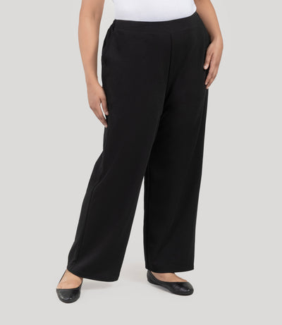 Plus size woman wearing JunoActive's Junonia Classic Pocketed black Plus Size pants on a plain background.
