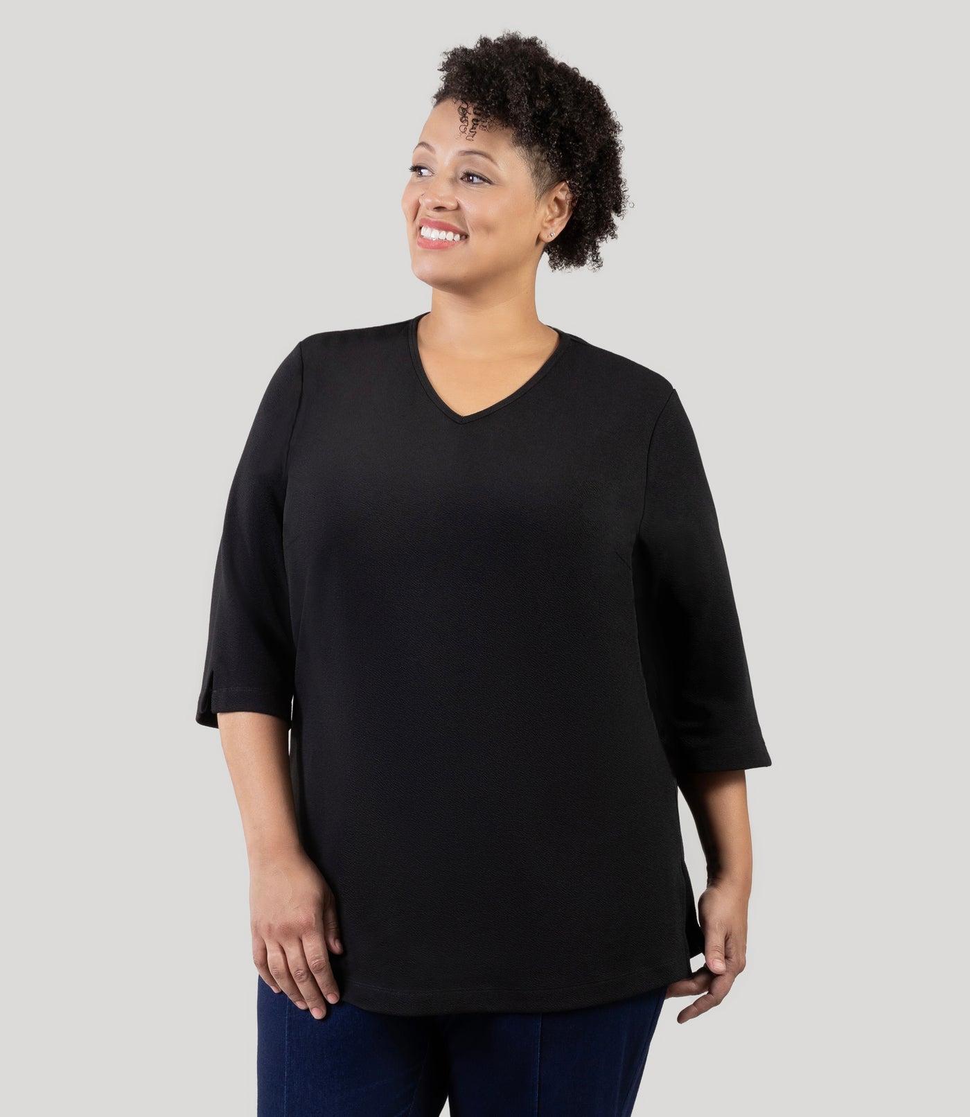 Plus Size Woman wearing Junonia Classic 3/4 Sleeve V-Neck Tunic black Plus Size top. Top features v-neck, 3/4 sleeves and vent notches on each sleeve and side hem.