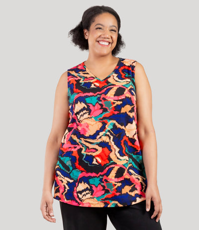 Plus size model, facing front, wearing JunoActive's Junonia Classic Sleeveless Plus Size Top in Modern Ikat print. Sleeveless top features v-neck and side vents at hem.