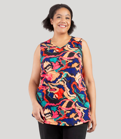 Plus size model, facing front, wearing JunoActive's Junonia Classic Sleeveless Plus Size Top in Modern Ikat print. Sleeveless top features v-neck and side vents at hem.