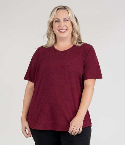 JunoActive model, facing front, wearing soft supreme scoop neck short sleeve top in color heather cranberry. Her arms are by her side. Length of sleeve is about 1.5 inches above elbow.