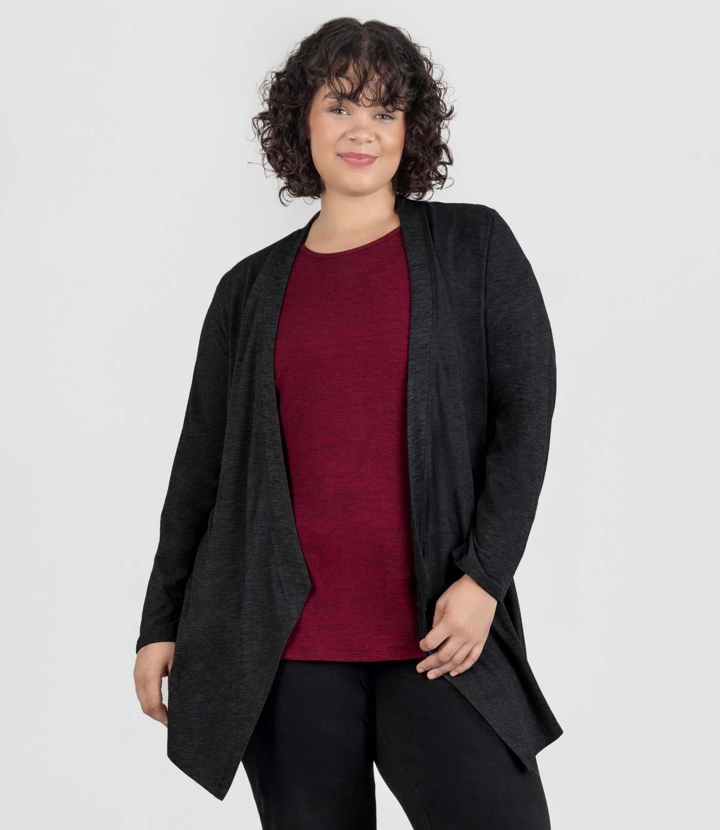 JunoActive Model, facing front, wearing SoftSupreme Cardigan in Heather Black, hands by her side.
