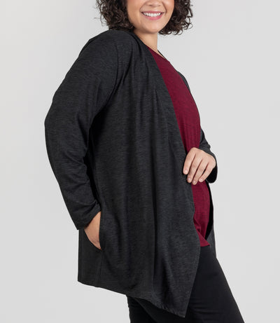 JunoActive Model, facing side, wearing SoftSupreme Cardigan in Heather Black, close up of hand in pocket.
