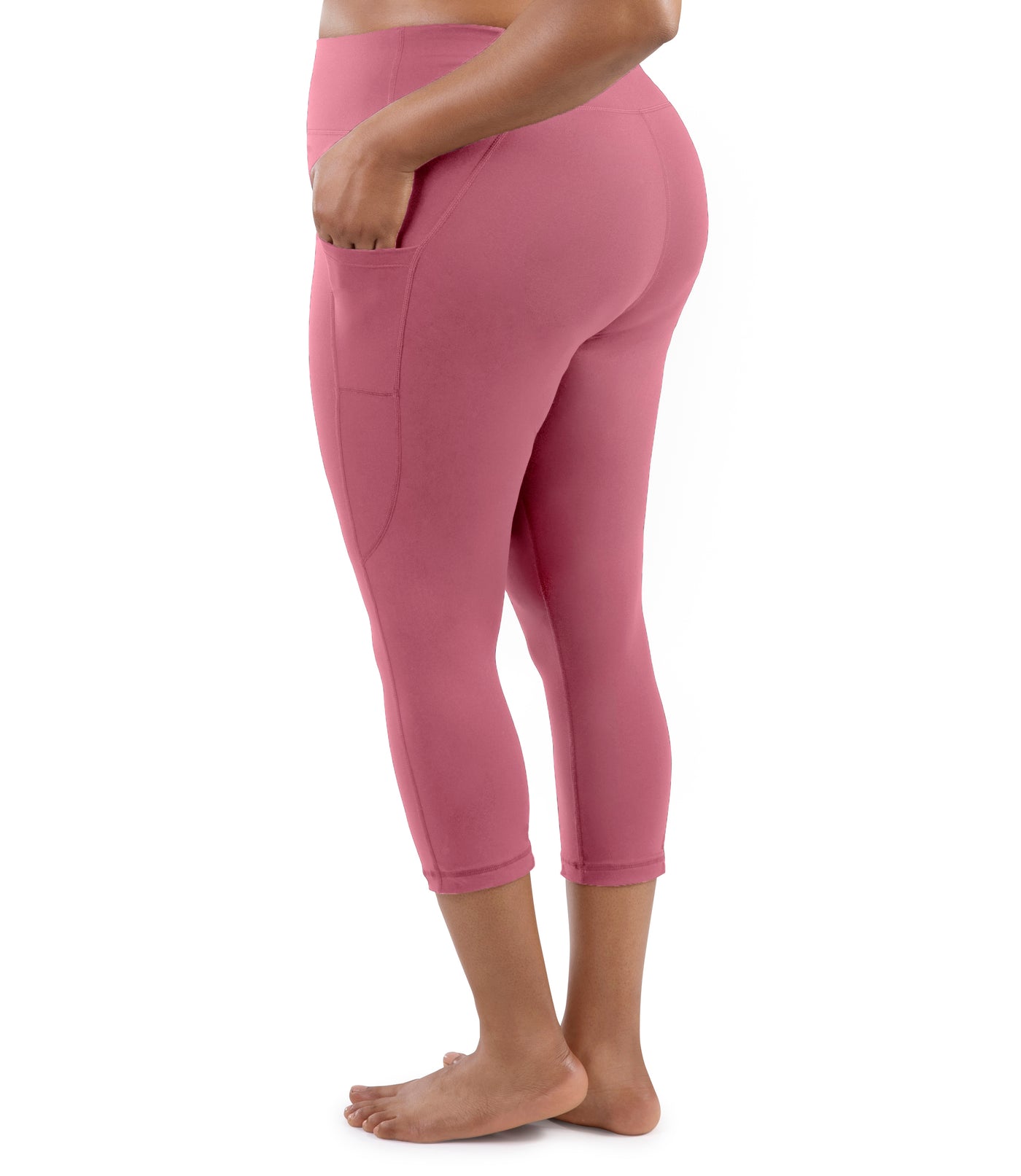 Bottom half of plus sized woman, facing back, wearing JunoActive JunoStretch Side Pocket Capris in warm mauve. The hem falls a few inches above ankle and have pockets on both sides.