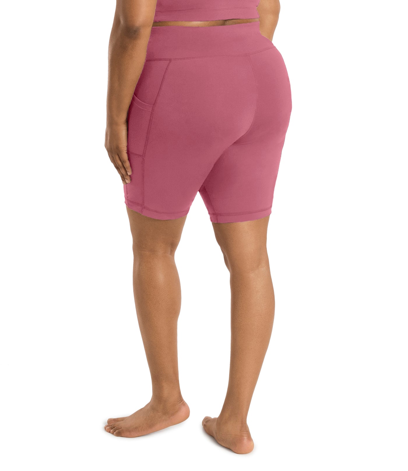 Plus size woman, back view with hands by side, wearing JunoActive JunoStretch Side Pocket Short in warm mauve. The hem is a few inches above the knee.