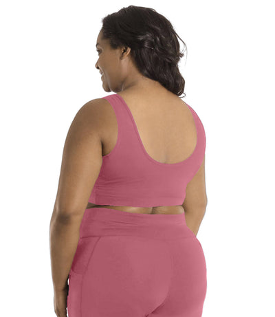 Plus size woman, facing back, wearing JunoActive plus size JunoStretch Scoop Bra in mauve. The woman is wearing black plus size JunoActive leggings.Her arms fall naturally to her side with her hands on her thighs.