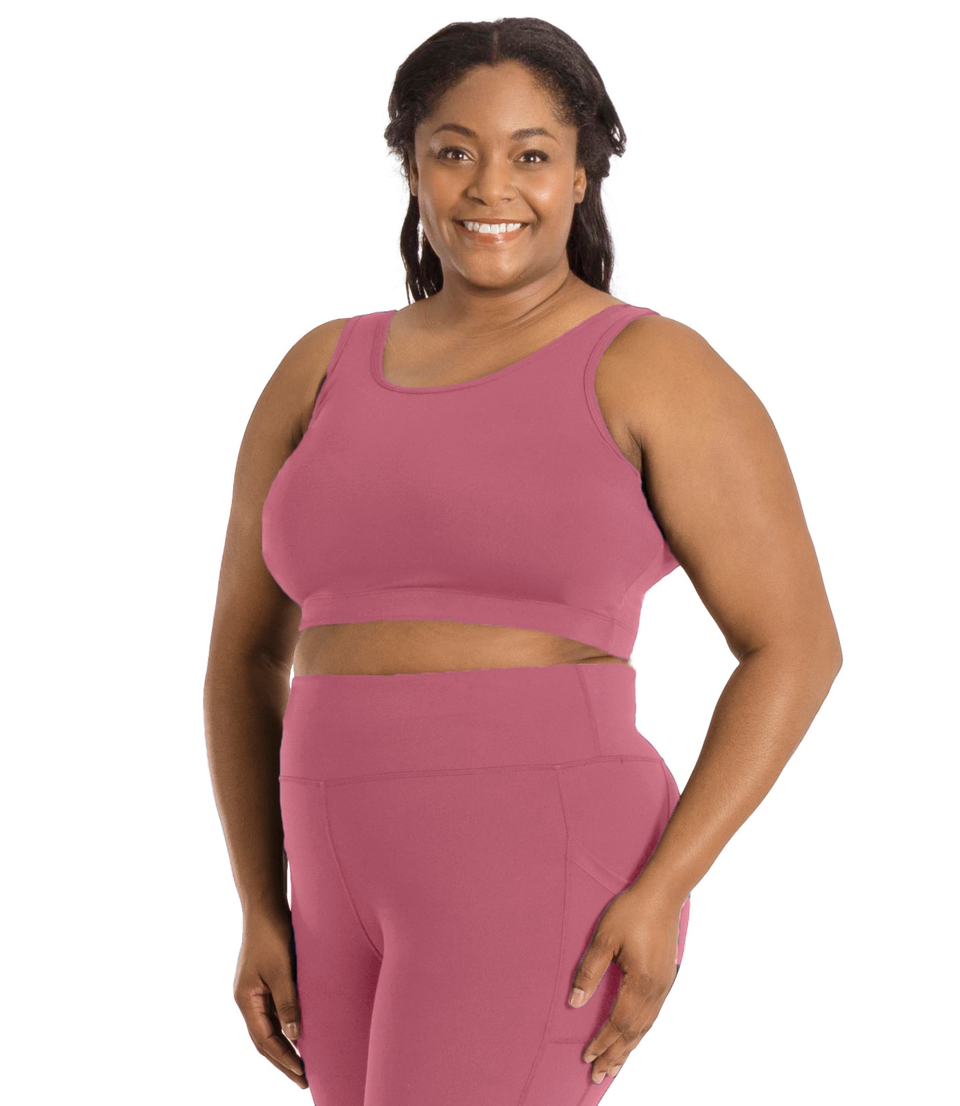 Plus size woman, facing front, wearing JunoActive plus size JunoStretch Scoop Bra in mauve. The woman is wearing black plus size JunoActive leggings.Her arms fall naturally to her side with her hands on her thighs.