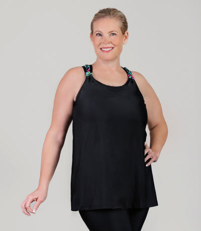 Plus size model wearing JunoActive's QuikEnergy Kona plus size tankini, featuring Night Lillies and black print, facing front and left hand on hip. 