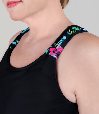 Close up of plus size model wearing JunoActive's QuikEnergy Kona plus size tankini, featuring Night Lillies and black print. Detail photo of the products strap.