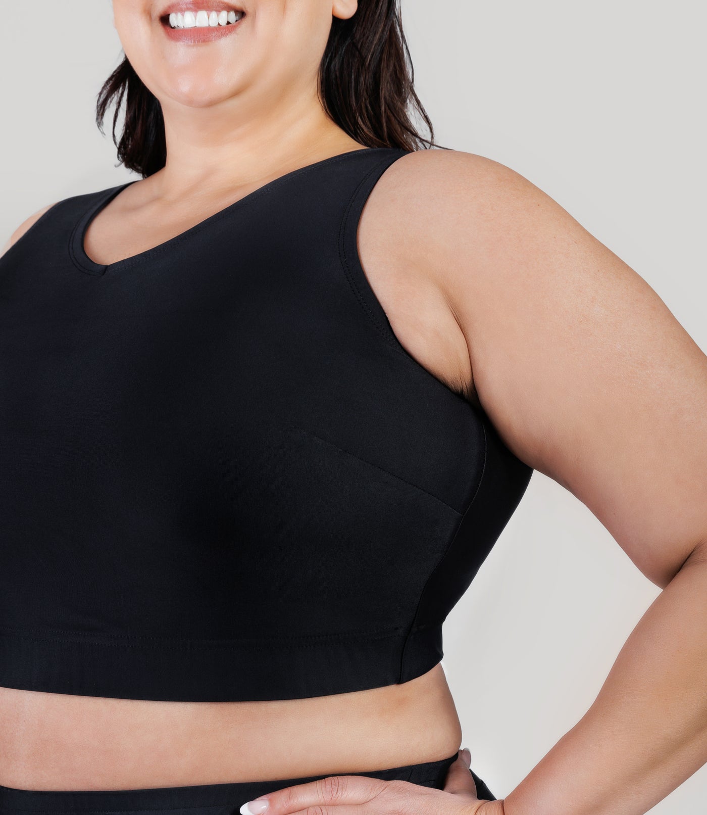 Plus size model, wearing JunoActive's QuikEnergy Full Fit plus size swim bra. Close up of the detail on the side of swim bra.