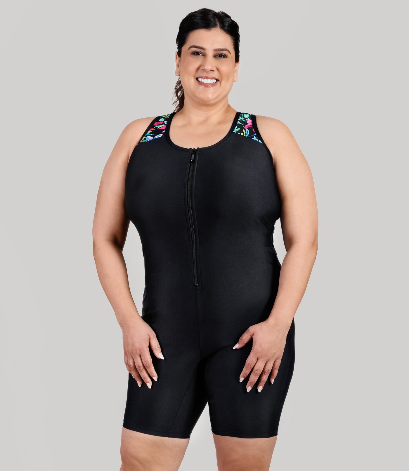 Plus size model, wearing JunoActive's QuikEnergy Racerback Zip Front plus size aquatard, facing front with her hands down by her side.