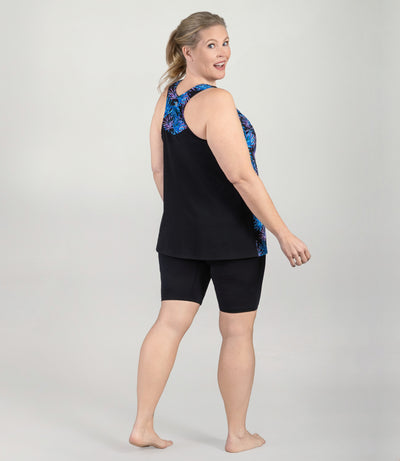 Plus size model, facing back with head turned front looking at camera, wearing AquaSport Hanalei Plus size Tankini Top Jewel Palmetto Print.
