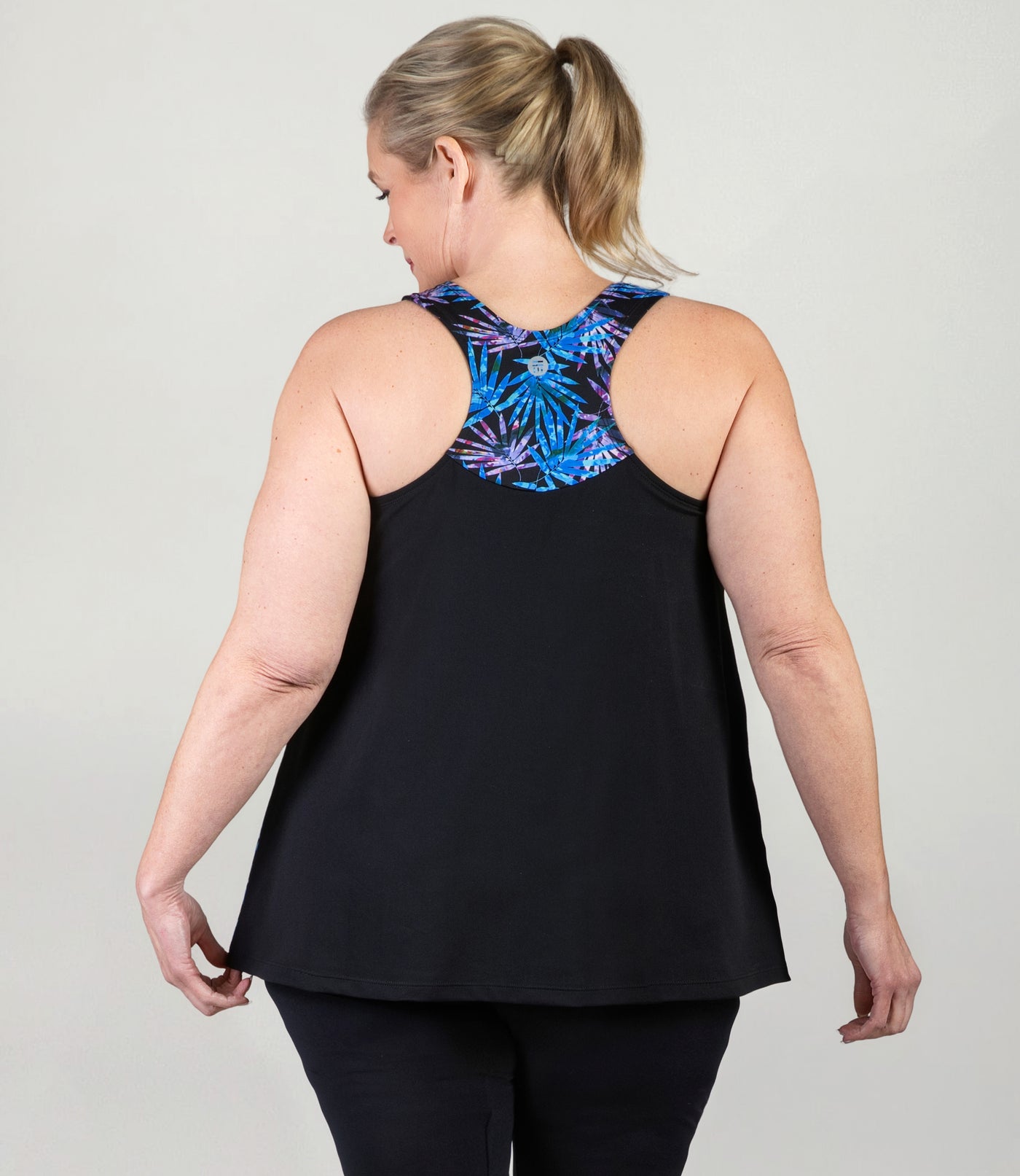 Plus size model, facing back, wearing AquaSport Hanalei Plus size Tankini Top Jewel Palmetto Print.